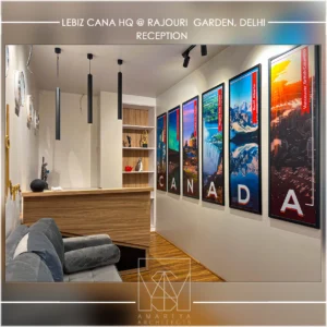Stylish office reception with framed wall art, wooden flooring and contemporary lighting by interior design companies in Delhi NCR