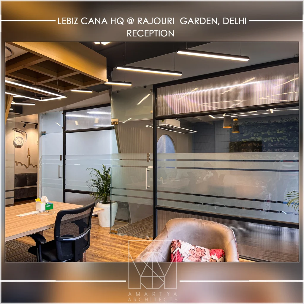 Corporate office reception at Rajouri Garden Delhi with glass partitions, modern lighting and seating by commercial architects expert Amartya architects in Delhi NCR.