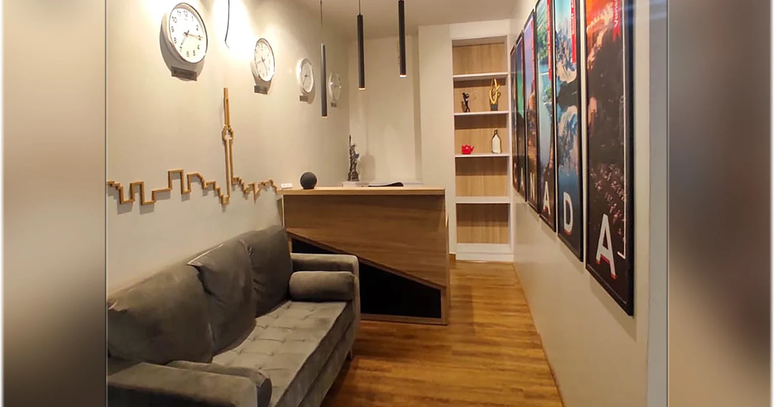 Office reception waiting area with modern sofa seating, wall décor and warm lighting designed by interior designers in Delhi.