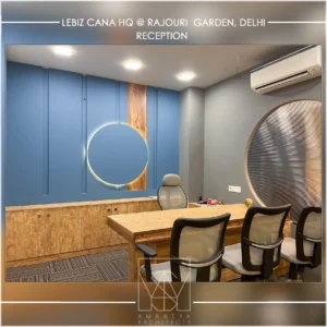 Modern office cabin interior with blue accent wall, wooden furniture and circular design element by commercial interior designers amartya architects.