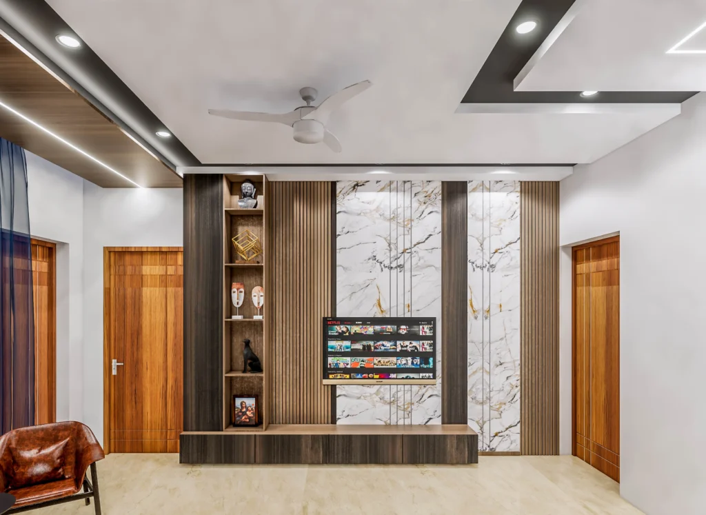 Contemporary TV unit and media wall design with marble cladding, wooden fins and integrated storage, created by living room interior designers near me and interior design firms near me.