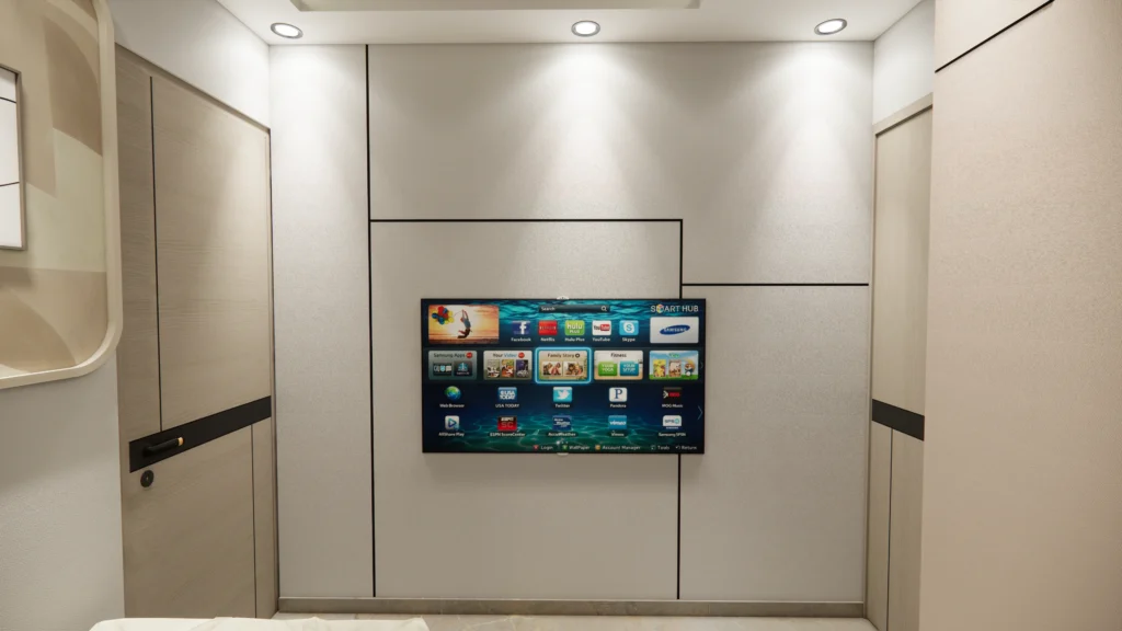 Minimal bedroom TV unit design by bedroom interior designer near me, showcasing clean wall paneling, concealed wiring and modern home interior design for apartment bedrooms in Delhi NCR.