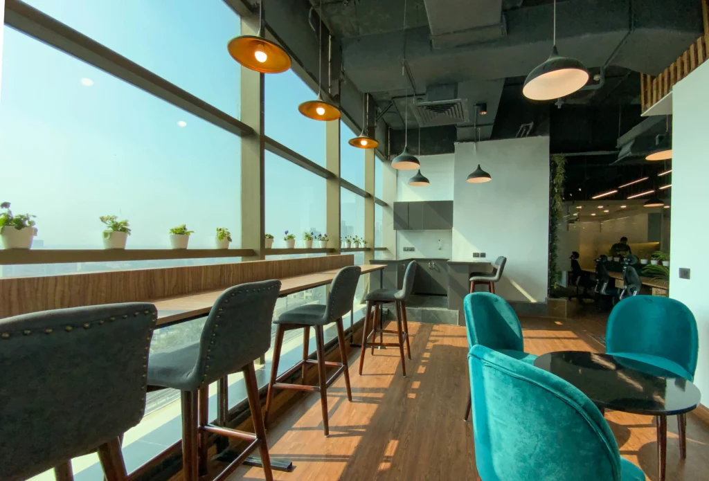 Office cafeteria interior design with wooden flooring and pendant lights at Cellcore HQ