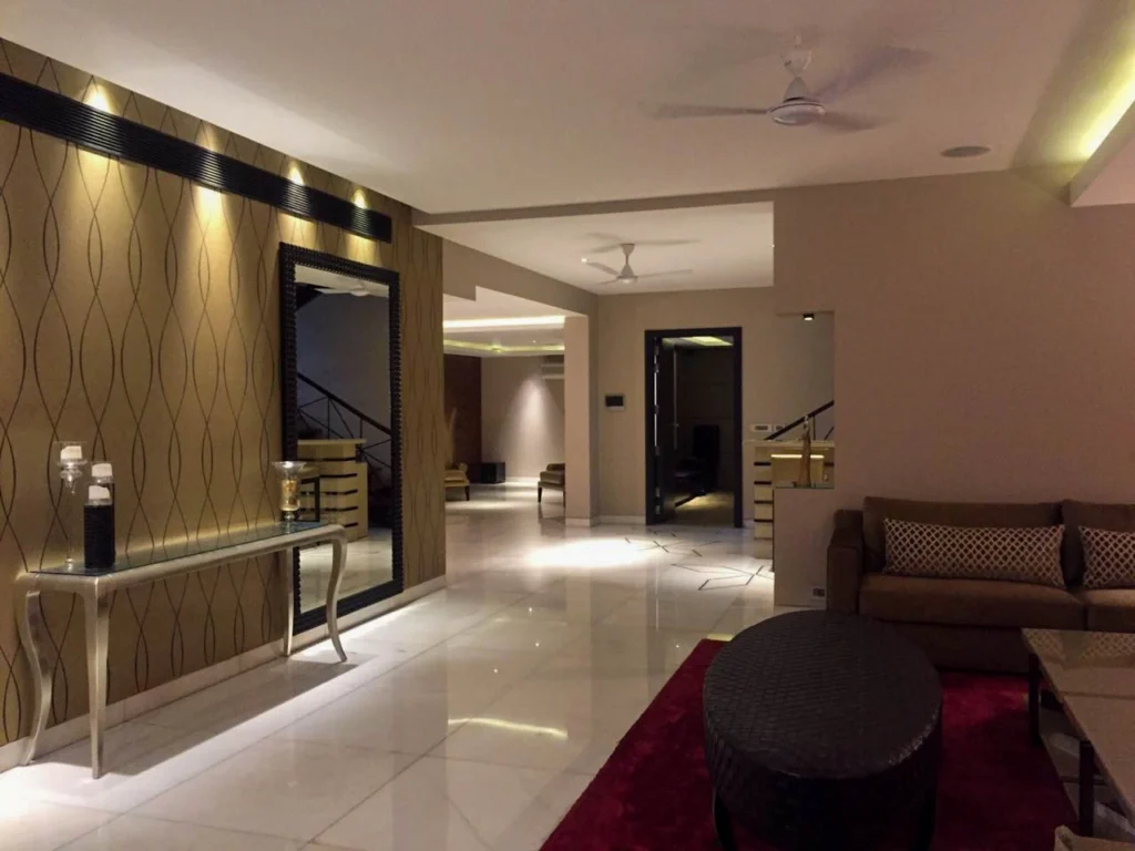 Modern home interior corridor with designer console table, mirror paneling, premium flooring and ambient lighting, planned by a residential interior designer near me for a contemporary Delhi home.