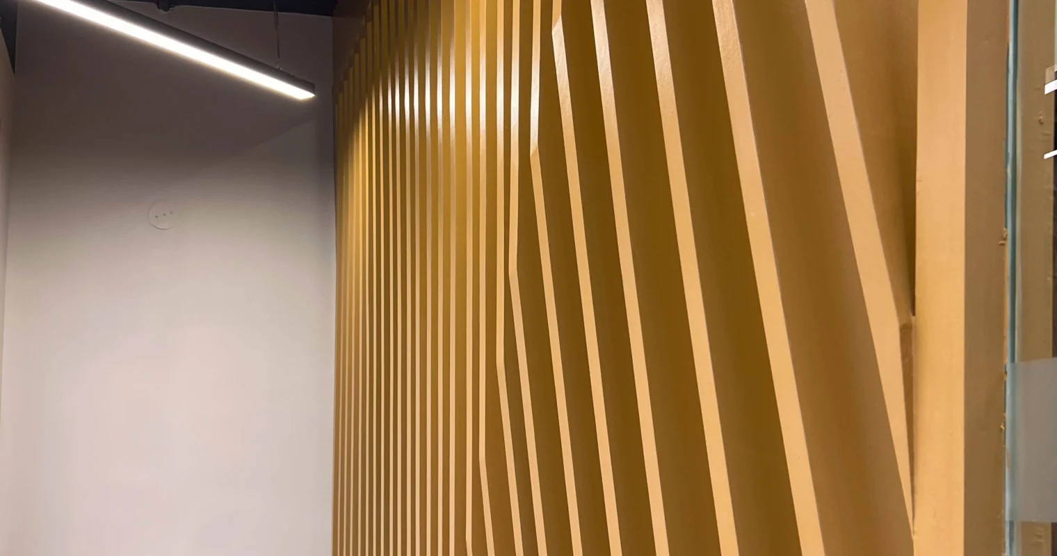 Decorative wooden wall panel with linear design and modern ceiling lights designed by interior designers amartya architects in Delhi NCR