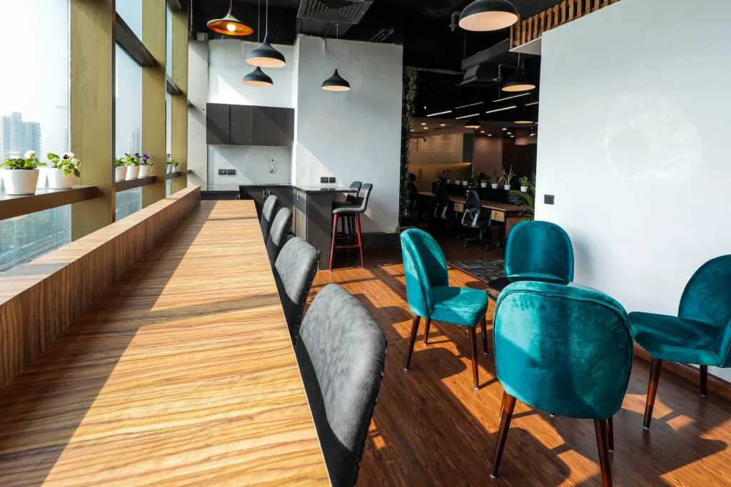 Contemporary office dining and lounge space with natural light and indoor plants