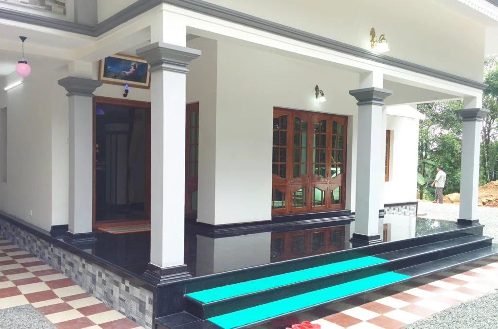 Spacious residential patio with classic columns, polished flooring and wooden doors, designed by Amartya Architects for a timeless home exterior design