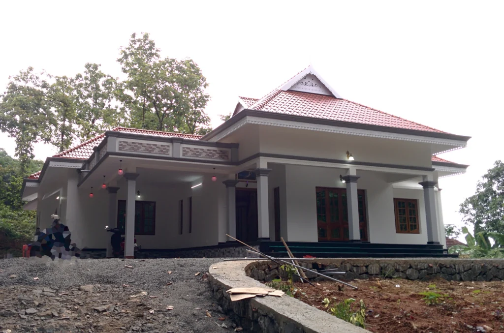 Traditional Kerala-style residential home with sloped tiled roof, front porch and columns, designed by Amartya Architects showcasing elegant residential architecture | residential architects | architect for home