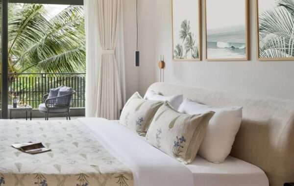 Modern bedroom with soft neutral tones, upholstered bed, wall art and balcony view designed by Amartya Architects, a leading interior designer company creating elegant residential interiors.