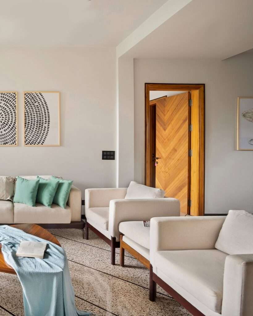 Minimal living room with comfortable seating, wooden accents, neutral tones, and clean layout designed by Amartya Architects for contemporary home interiors.
